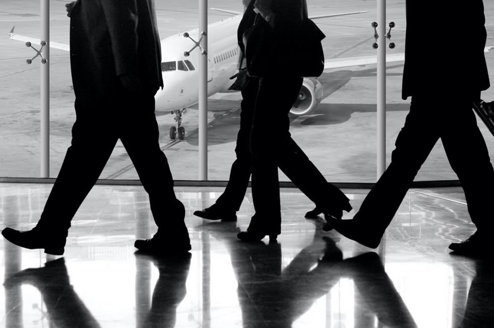 Employees at the airport discussing how Payhawk's virtual cards simplified their business travel expense workflows